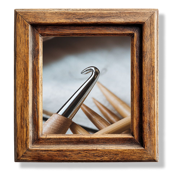 A close up of a crochet hook in a wooden frame.
