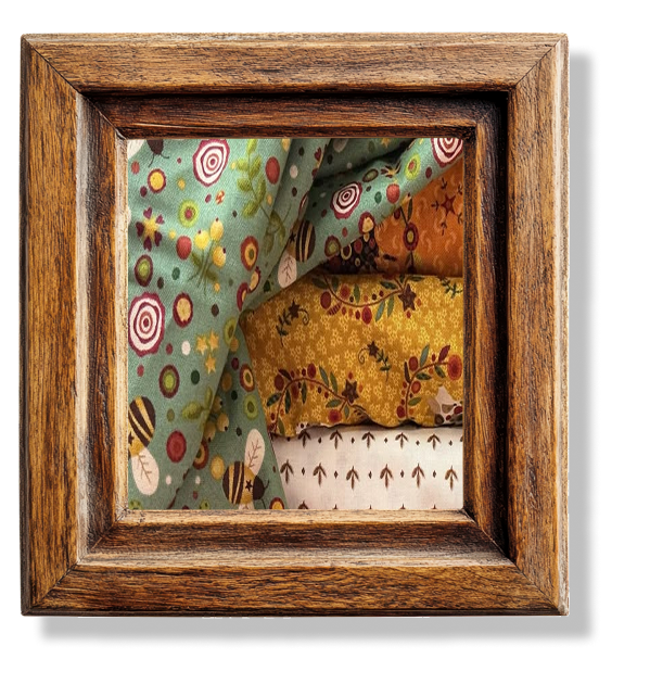 A close up of different patterned fabrics in a wooden frame.